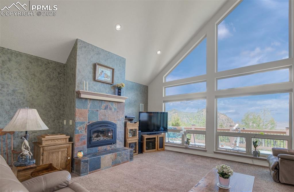 Image 5 of 46: Living room with tall ceilings, a wood burning fireplace with a custom mant