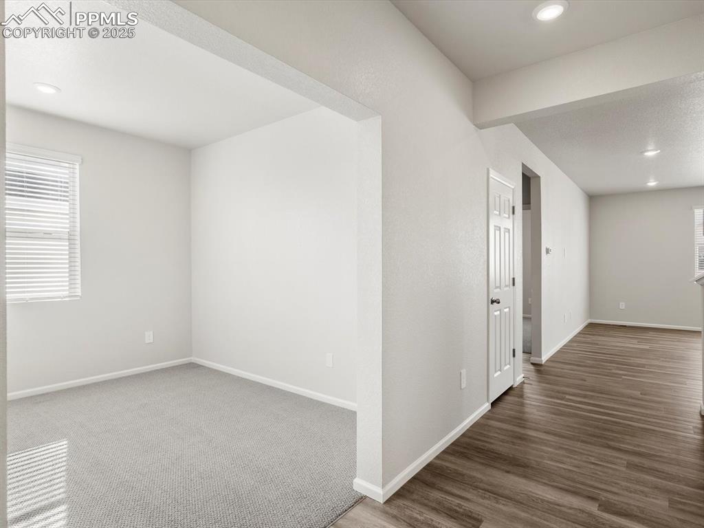 Image 10 of 28: Empty room featuring recessed lighting and dark wood-style floors