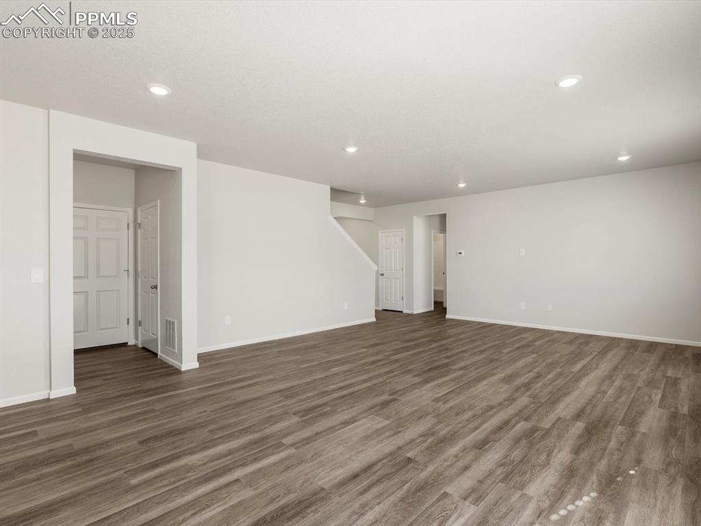 Image 11 of 28: Unfurnished living room featuring wood finished floors and recessed lightin