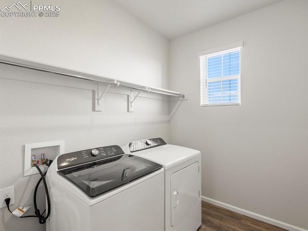 Image 21 of 28: Laundry area with dark wood-style floors and washing machine and dryer