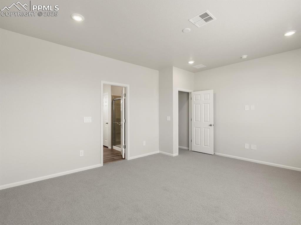 Image 23 of 28: Unfurnished bedroom featuring carpet floors, recessed lighting, and ensuite