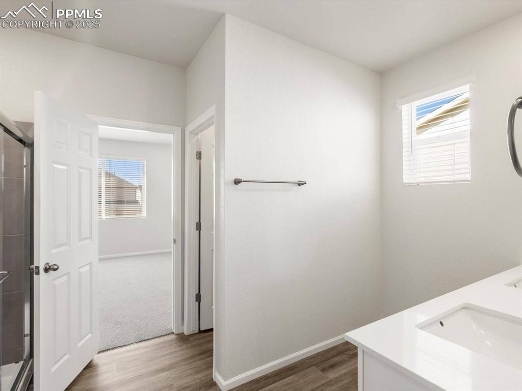 Image 25 of 28: Bathroom featuring double vanity, healthy amount of natural light, dark woo