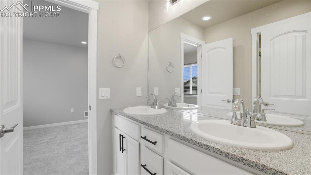 Image 28 of 50: Bedrooms 1 & 2 share a Shower Bathroom with dual sink vanity with quartz co