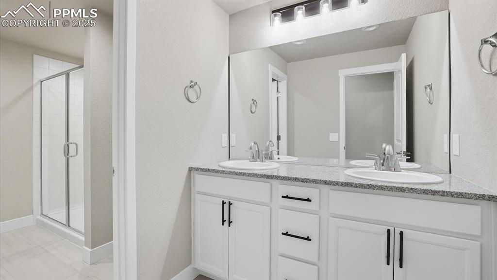 Image 40 of 50: Double sink vanity with quartz countertops in Basement Bathroom.