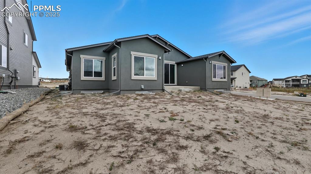 Image 46 of 50: Rear view of home and backyard with concrete patio and gas stub for grill.
