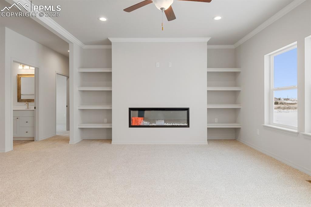 Image 10 of 22: Unfurnished living room with built in features, carpet flooring, recessed l