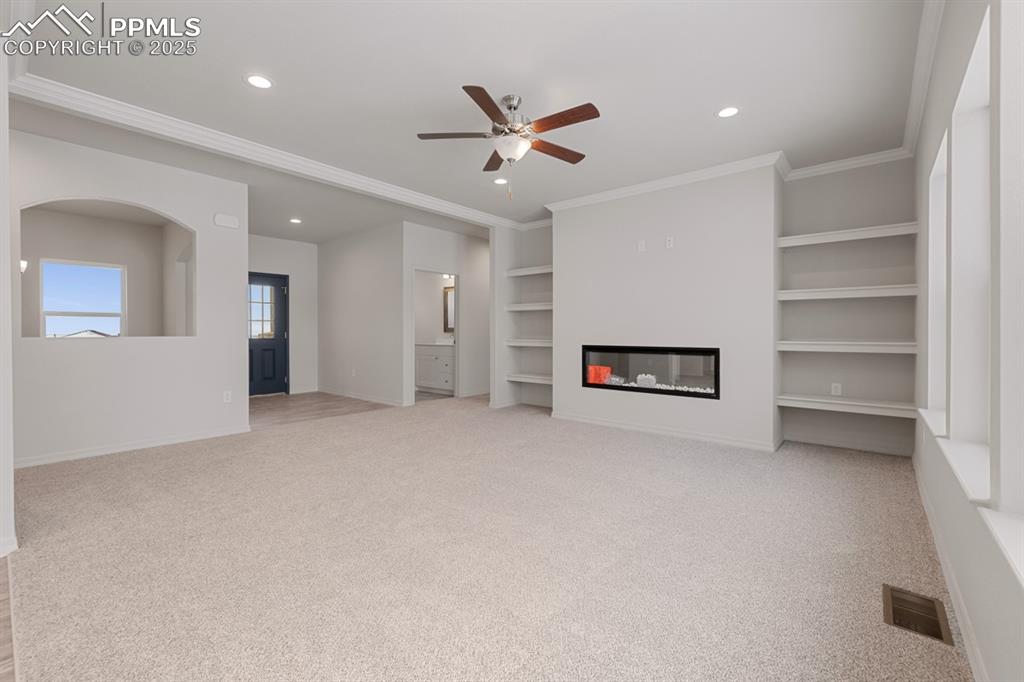 Image 11 of 22: Unfurnished living room featuring recessed lighting, a glass covered firepl