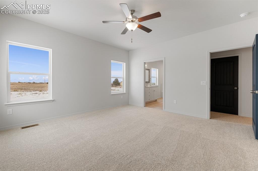 Image 17 of 22: Unfurnished bedroom featuring light colored carpet, ensuite bathroom, and a