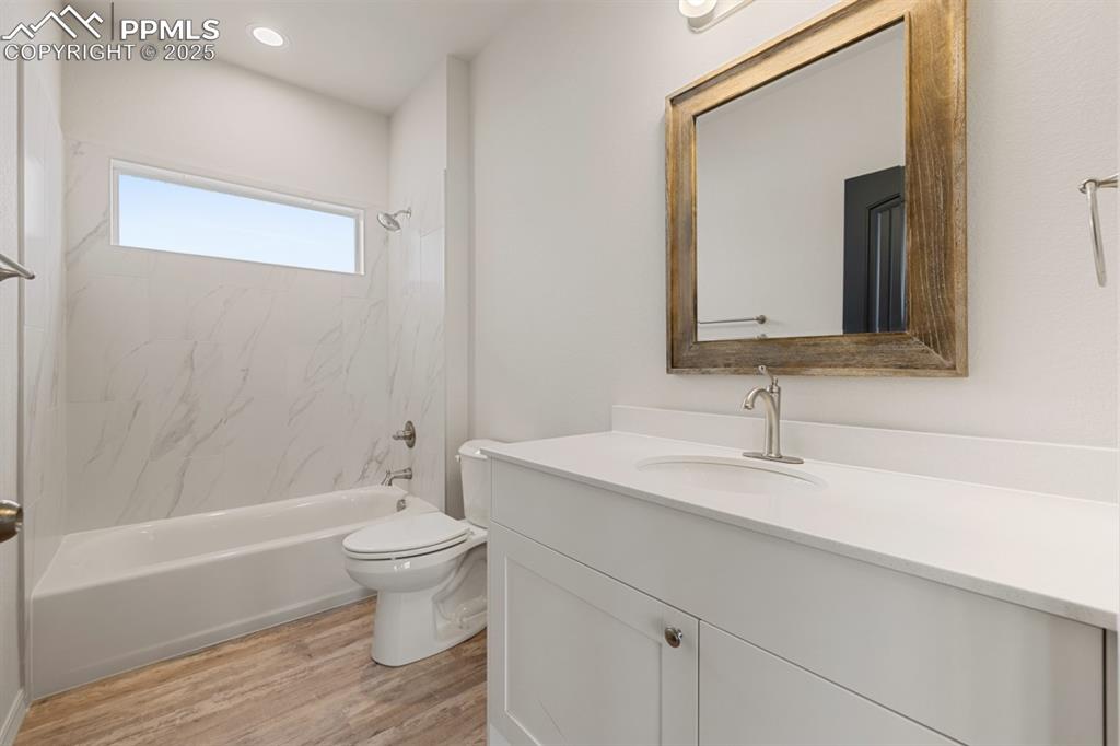 Image 22 of 22: Full bathroom featuring vanity, wood finished floors, and  shower combinati