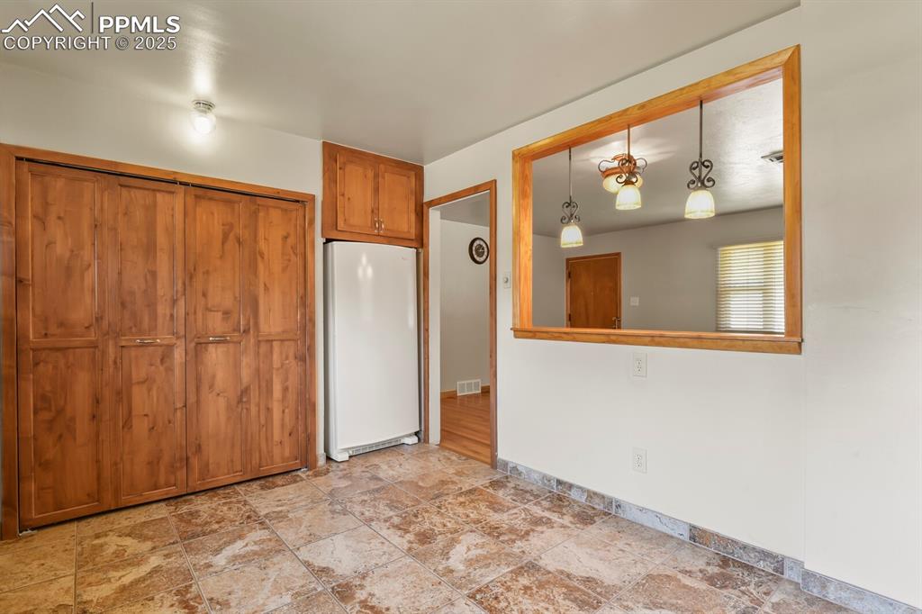 Image 11 of 24: Kitchen featuring laundry/ pantry closet, freestanding refrigerator, solid 