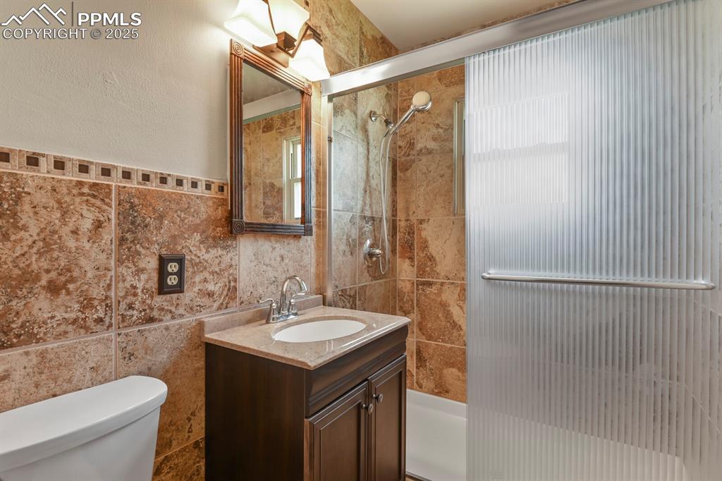 Image 12 of 24: Bathroom with tile walls and vanity