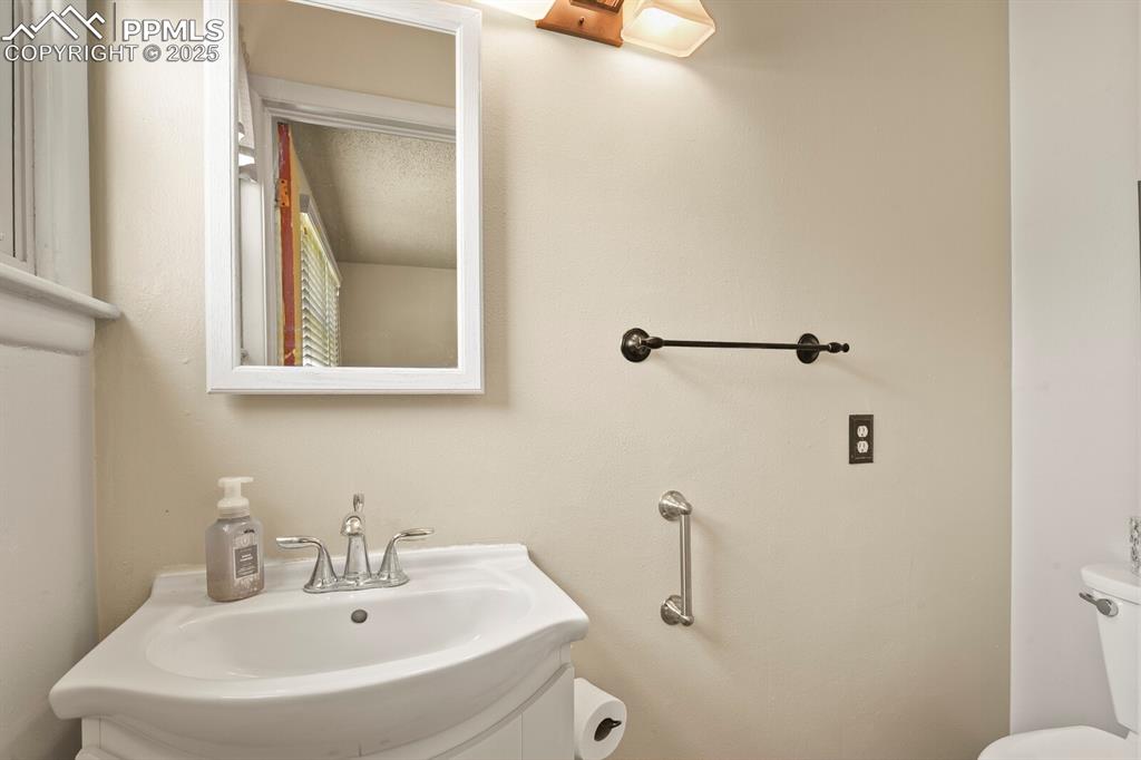Image 15 of 24: Primary half-bath featuring toilet and a sink