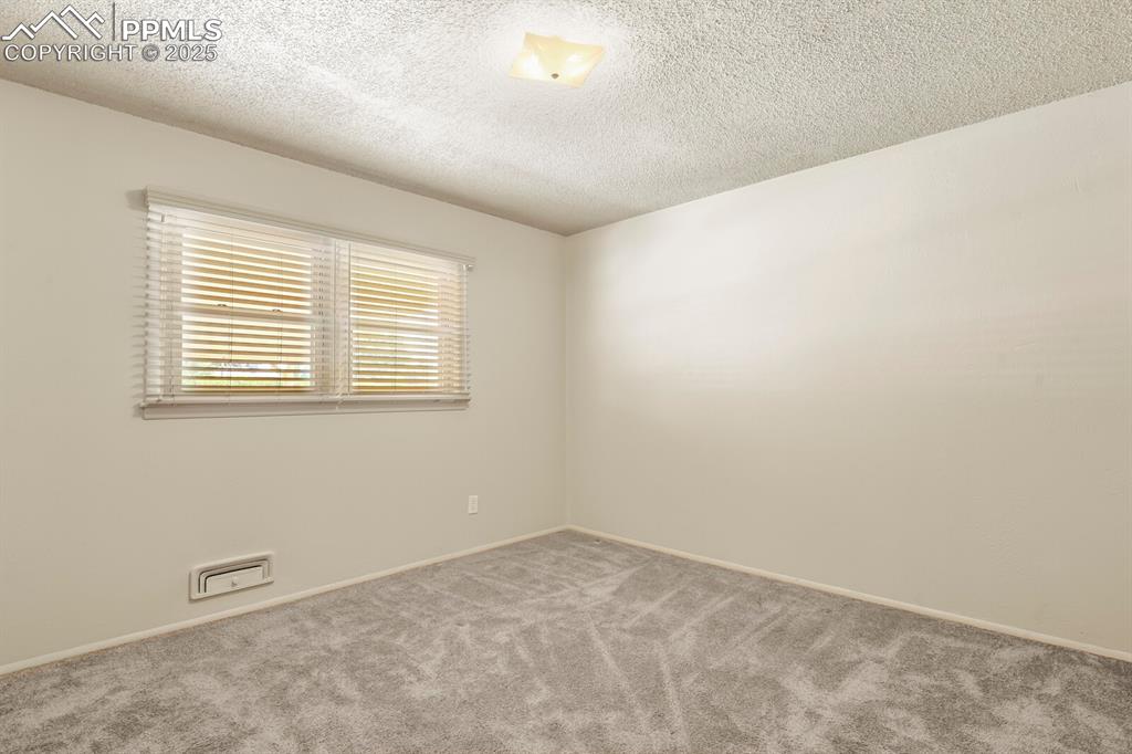 Image 16 of 24: Bedroom featuring carpet floors and large window with wood blinds