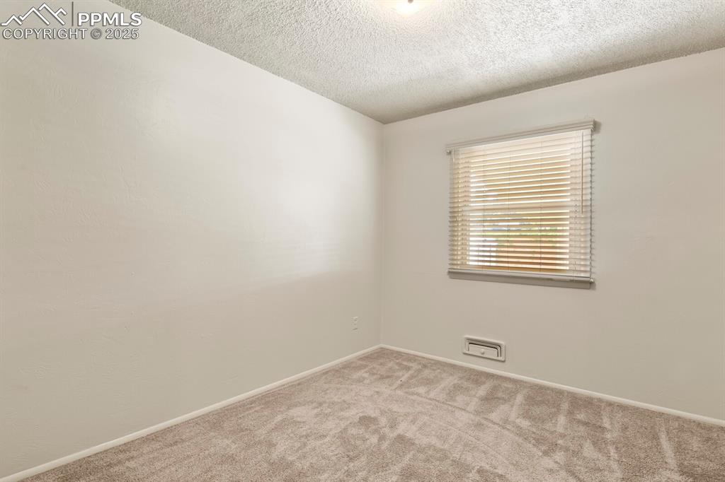 Image 17 of 24: Spare room featuring carpet floors, window with wood blinds