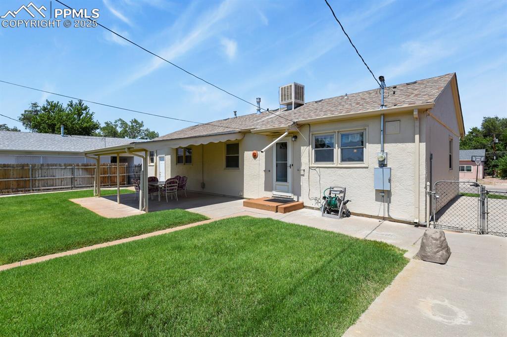 Image 22 of 24: Rear view of house with a gate, stucco siding, a patio, and roof with shing