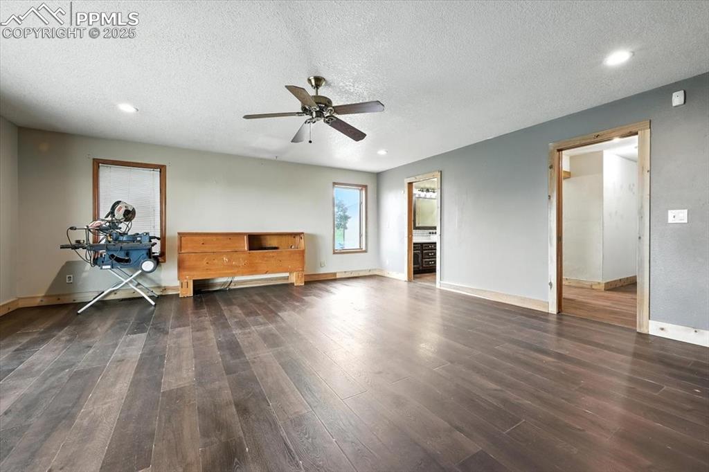 Image 14 of 29: Unfurnished living room featuring wood finished floors, a ceiling fan, a te