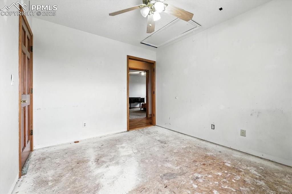 Image 19 of 29: Spare room with attic access and ceiling fan