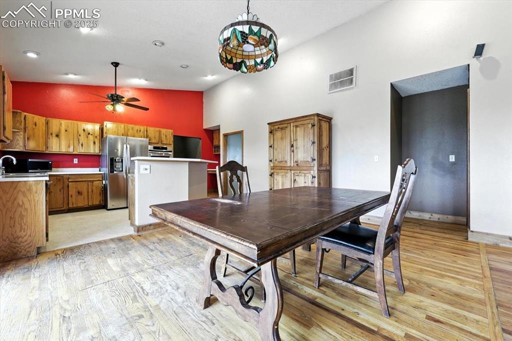 Image 8 of 29: Dining area featuring high vaulted ceiling, light wood-style flooring, and 