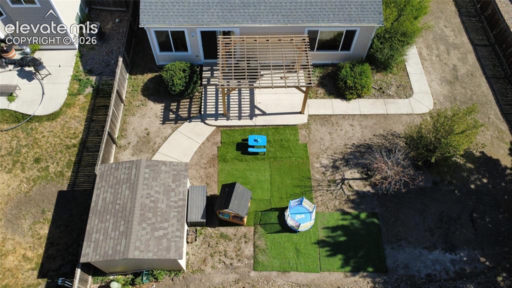 Image 30 of 31: Rear exterior featuring a pergola-covered patio, shed with shingled roof, a