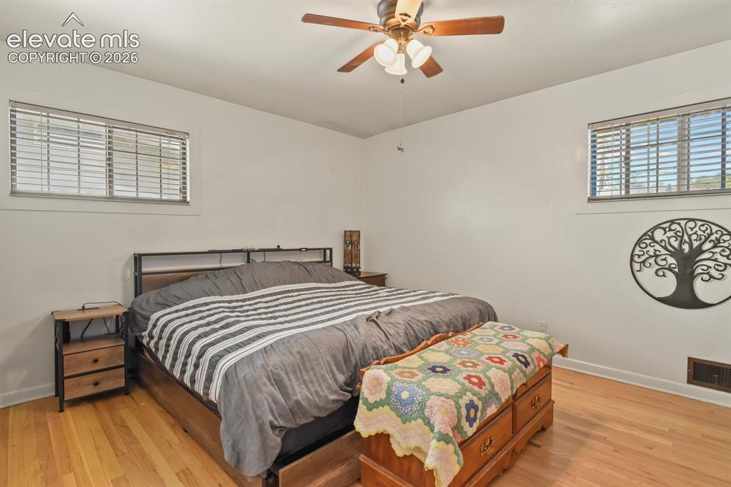 Image 10 of 28: Hardwood-finish flooring, two windows with horizontal blinds, and a ceiling