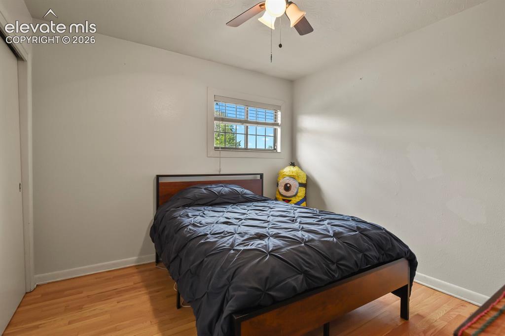 Image 14 of 28: Hardwood flooring, window with blinds, ceiling fan with integrated lighting