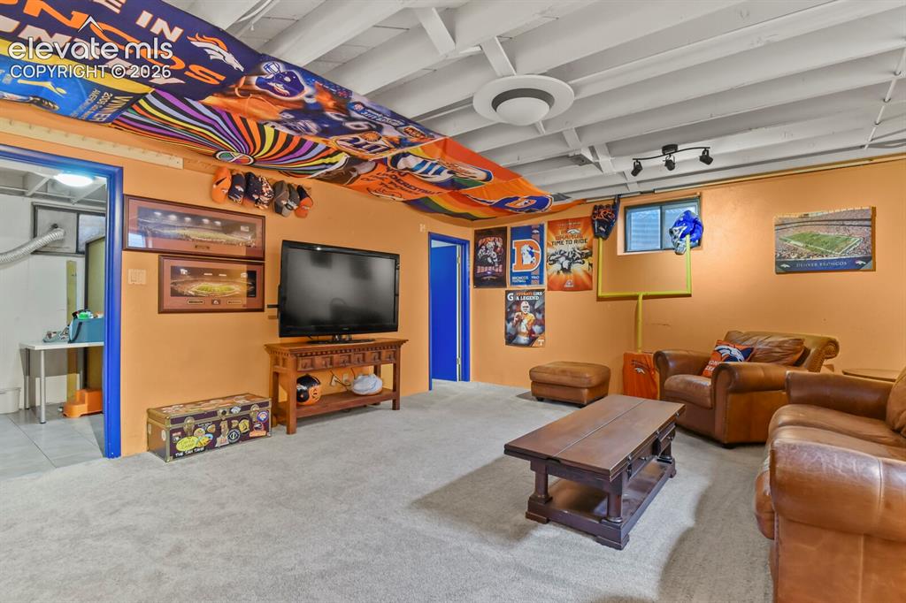 Image 17 of 28: Light-colored carpeting with orange-painted walls and a white exposed beam