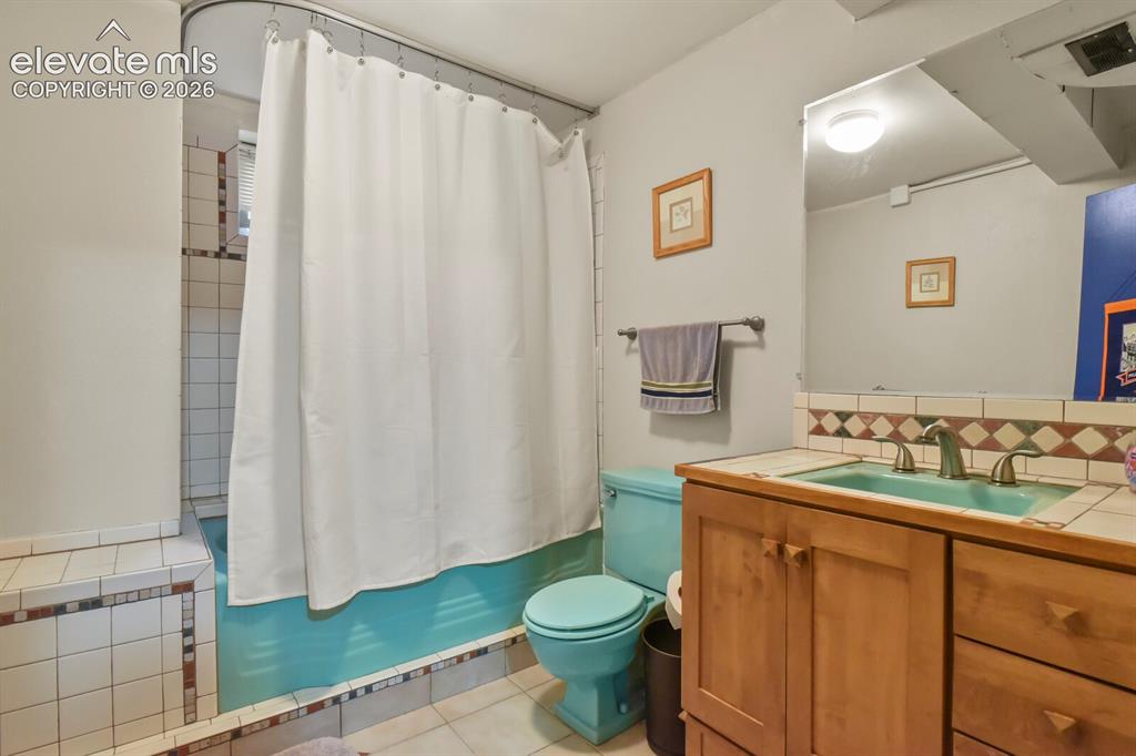 Image 20 of 28: Tile flooring and bathtub surround