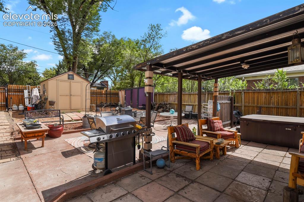 Image 22 of 28: Expansive outdoor patio with a built-in pergola, stone paver and concrete s