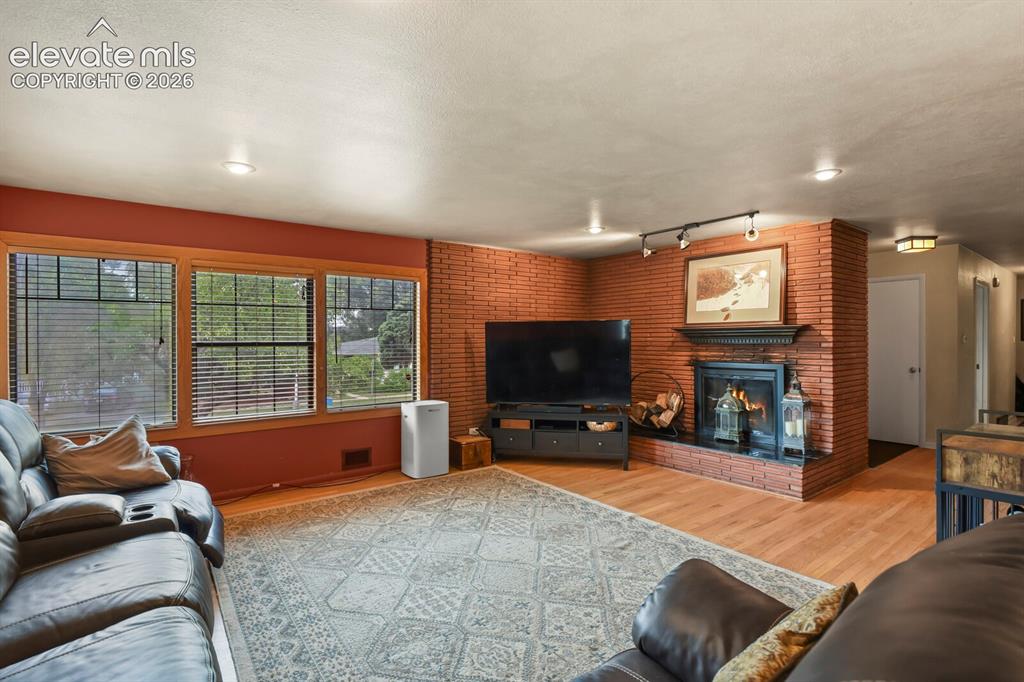 Image 4 of 28: Brick accent wall with a fireplace featuring an ornate mantel