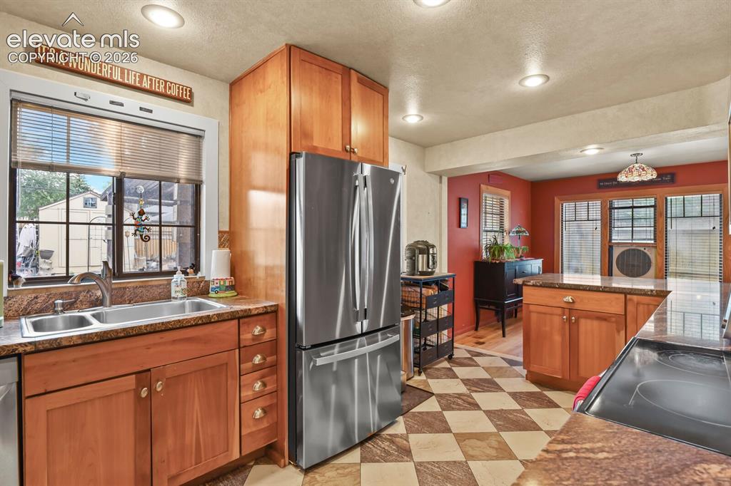 Image 8 of 28: Recessed ceiling lighting, wood cabinetry, stone countertops, stainless ste