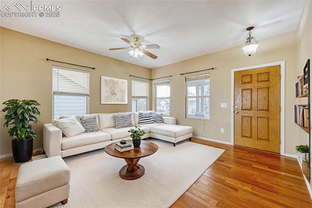 Image 3 of 38: Living area with a ceiling fan and light wood finished floors