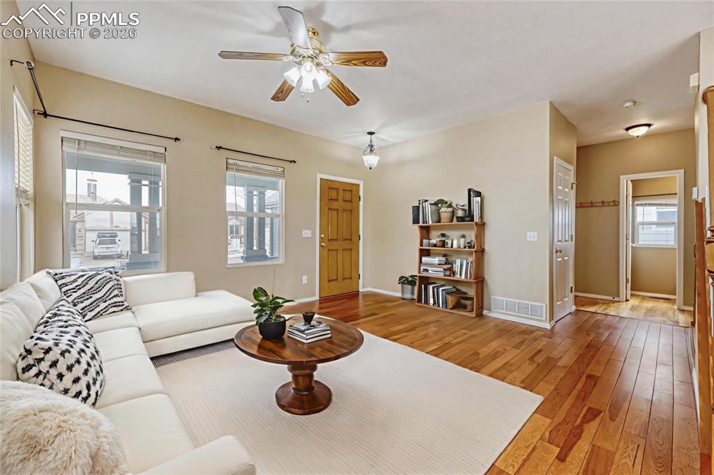 Image 5 of 38: Living room with light wood-style floors and ceiling fan