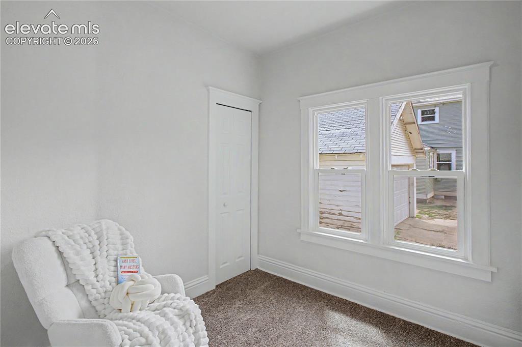 Image 10 of 19: White walls, double-hung windows, bi-fold closet door, and carpeted floorin