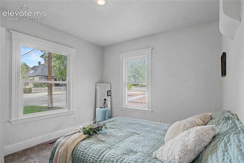Image 12 of 19: Recessed lighting, wood-finish flooring, and white trim molding around wind
