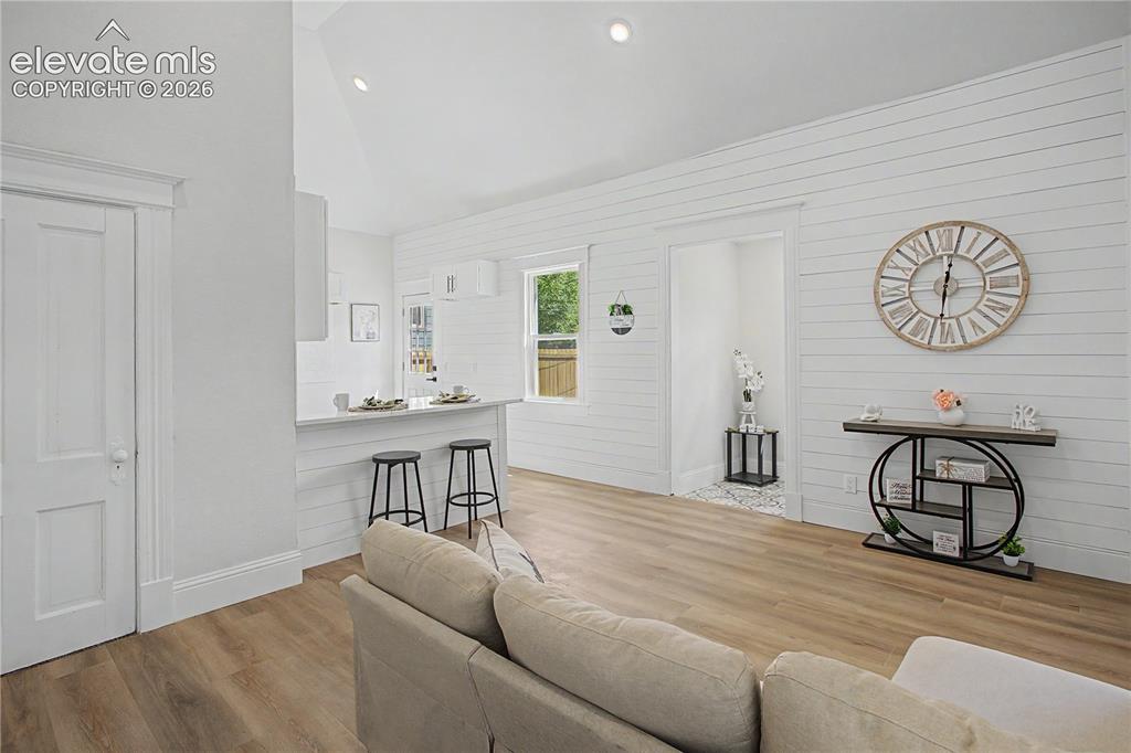 Image 3 of 19: Wood-finish flooring throughout, white shiplap accent wall, recessed lighti