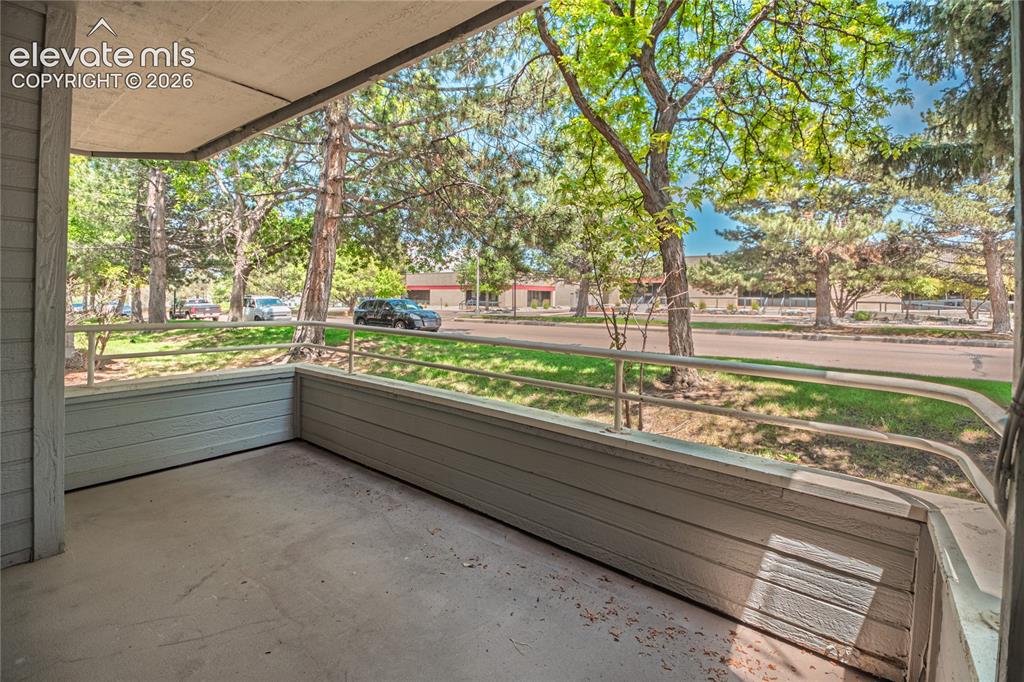 Image 10 of 37: Covered patio with concrete flooring, light blue siding, and a metal railin