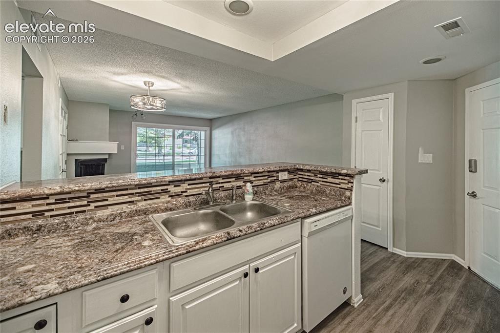 Image 13 of 37: Kitchen peninsula featuring a double basin stainless steel sink, granite-pa
