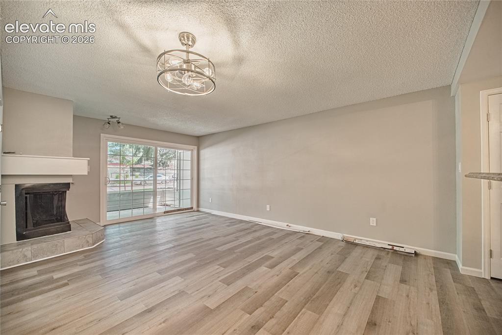 Image 16 of 37: Living area featuring a fireplace with a mantel, tile hearth, and wood-fini