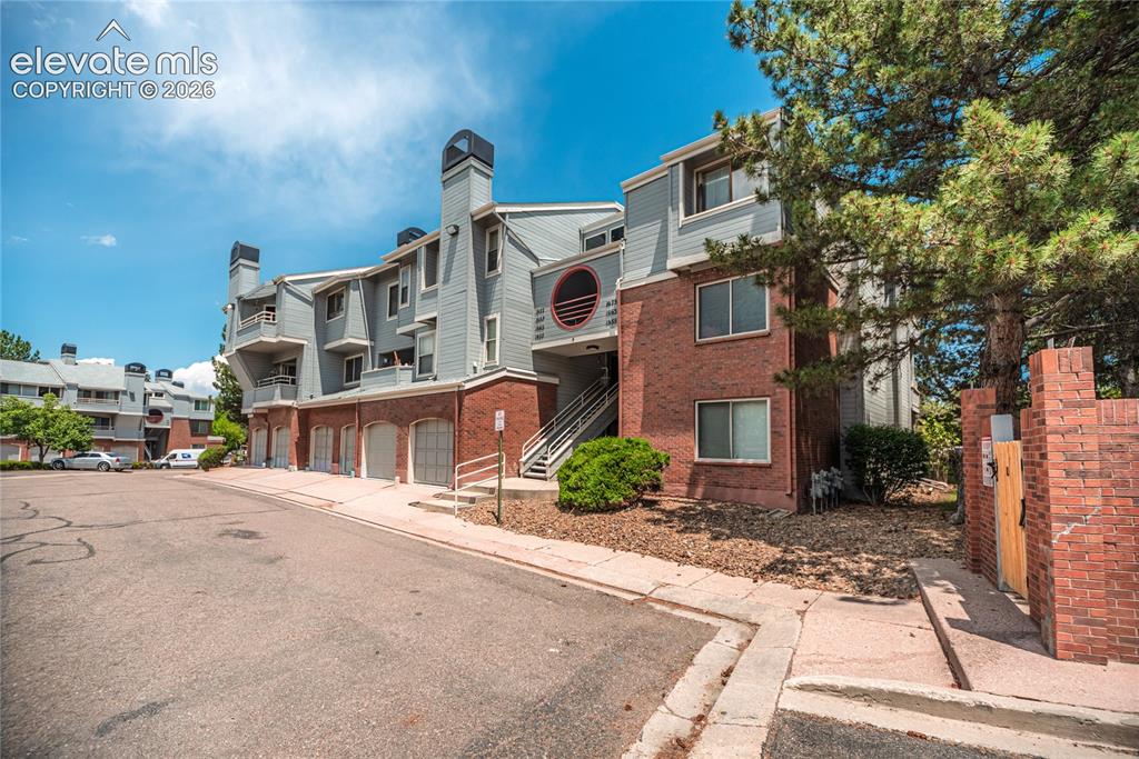 Image 2 of 37: Multi-level condominium building featuring a brick and siding exterior