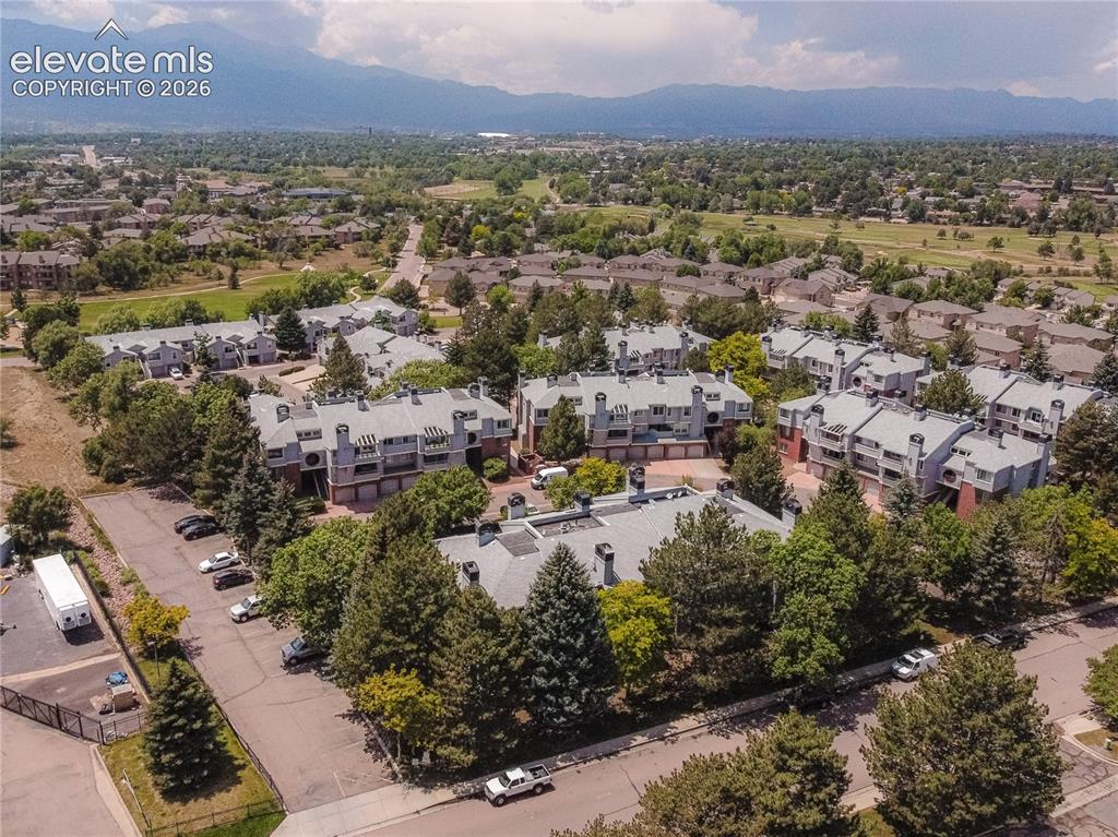 Image 25 of 37: Aerial perspective showcasing a community of multi-story townhomes with gre