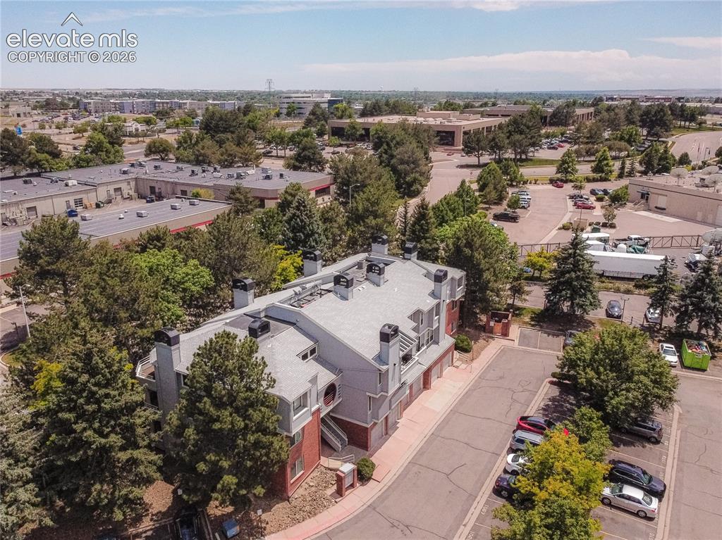 Image 33 of 37: Multi-level building featuring a gray roof, red brick accents, and multiple