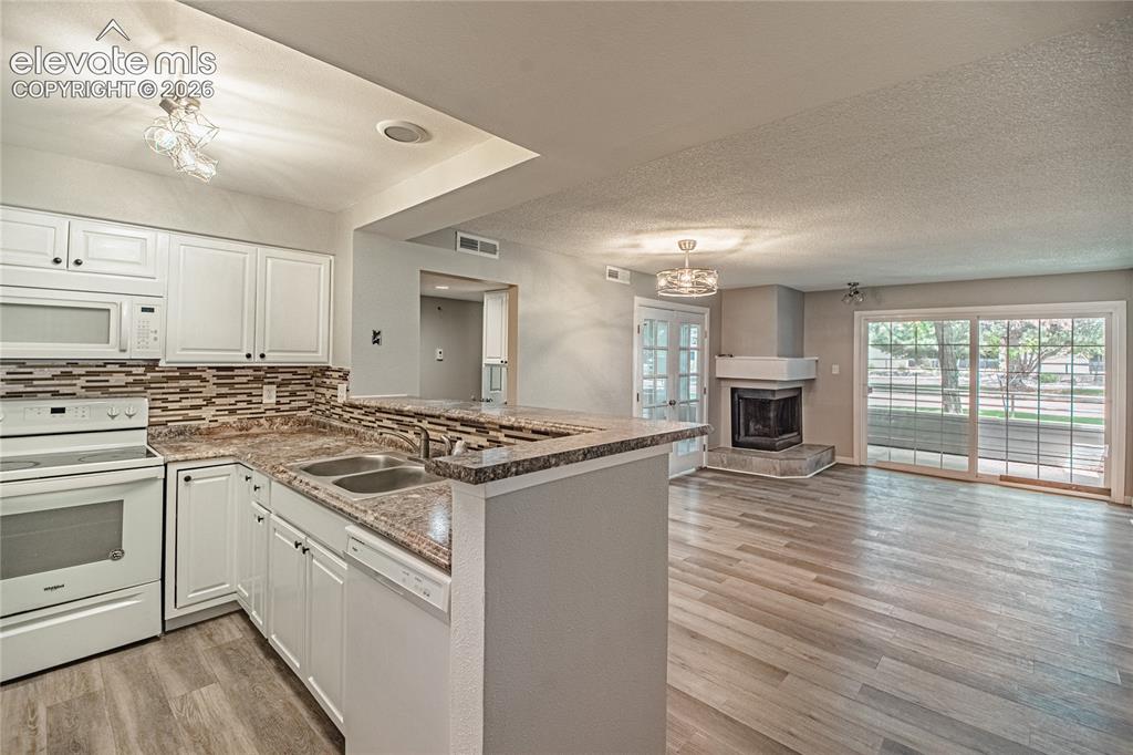 Image 5 of 37: Open-concept living space featuring wood-finish flooring, a kitchen with wh