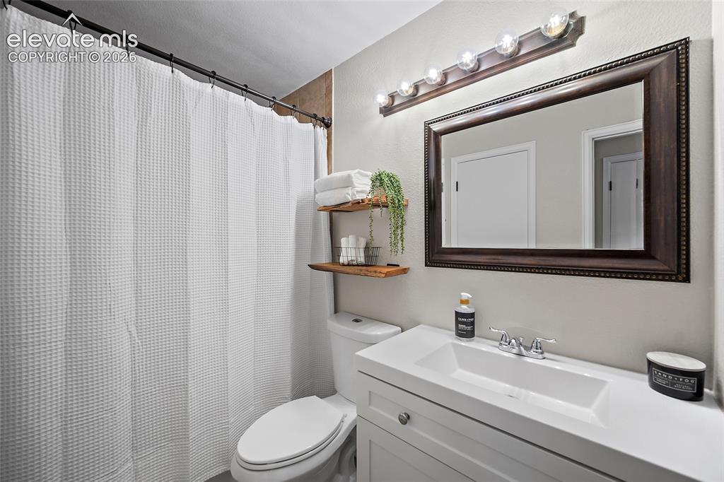 Image 15 of 37: Bathroom with a white vanity featuring an integrated sink and chrome faucet
