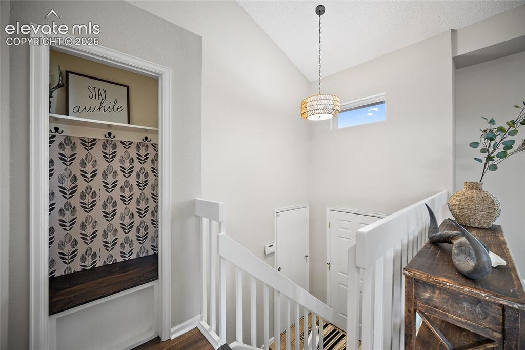 Image 18 of 37: Stairwell featuring white painted balusters and handrails, a wood-finish fl