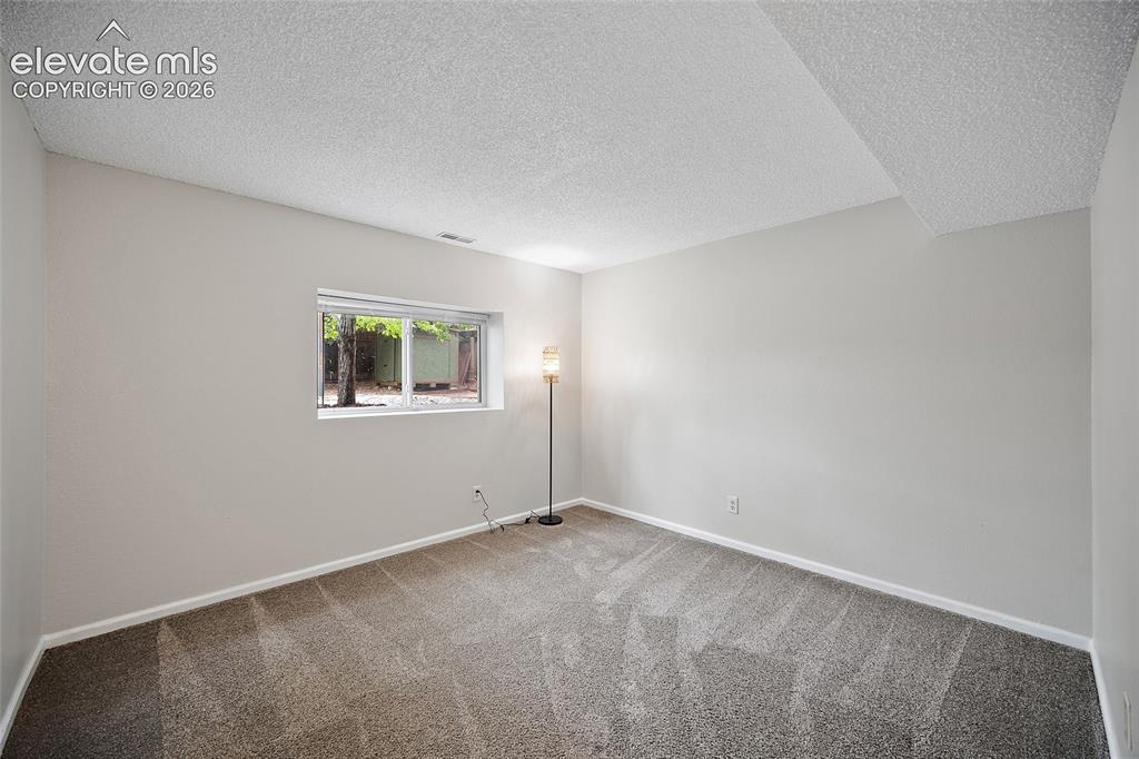 Image 25 of 37: Carpeted interior space featuring light-toned walls, white trim, and a wind