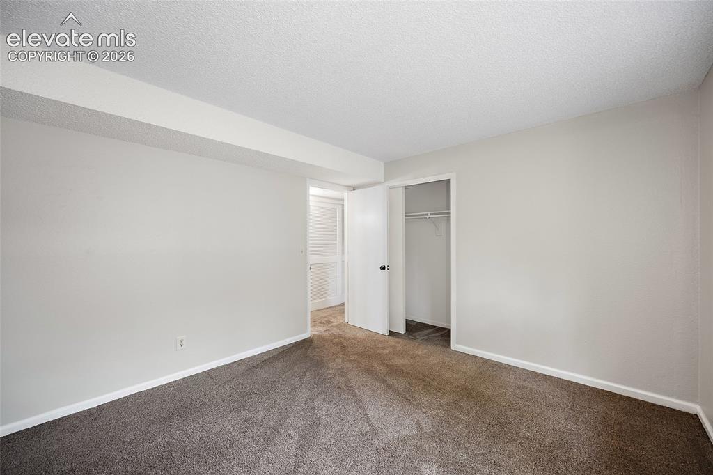 Image 26 of 37: Carpeted interior room featuring light gray walls, white trim, and a white 