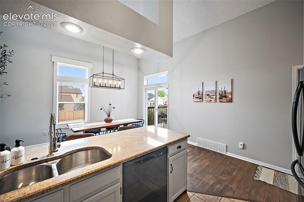 Image 8 of 37: Kitchen island with granite-finish countertop and stainless steel double si