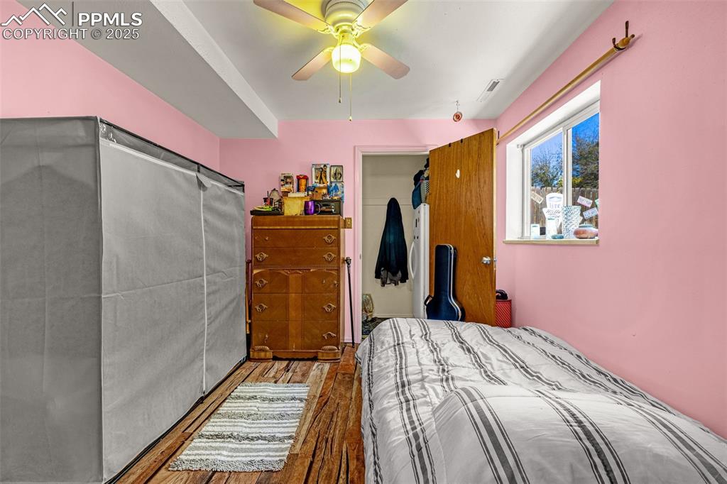 Image 11 of 25: Bedroom with wood finished floors and a ceiling fan