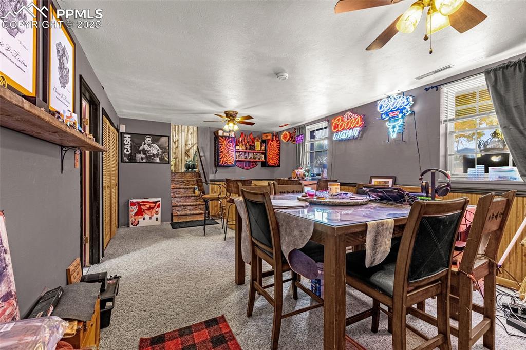 Image 13 of 25: Dining room with ceiling fan, light carpet, plenty of natural light, and a