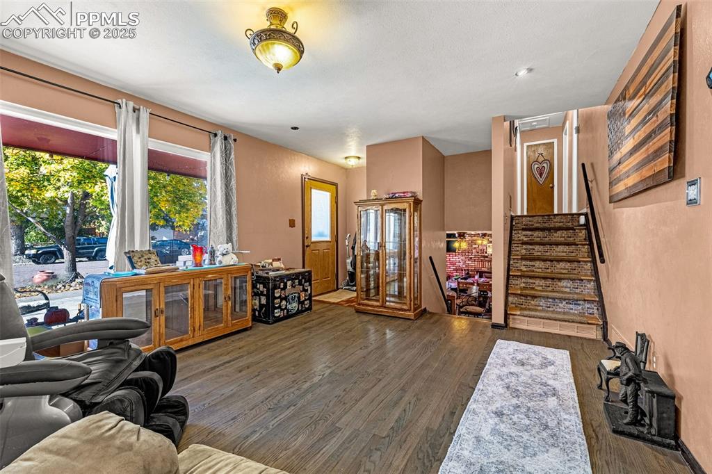 Image 4 of 25: Living room featuring stairs and wood finished floors